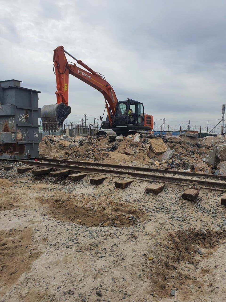 Hitachi excavator clearing rubble and rail track on PRASA Central Line corridor