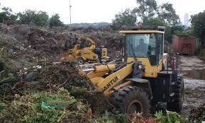 Loader handling green waste piles