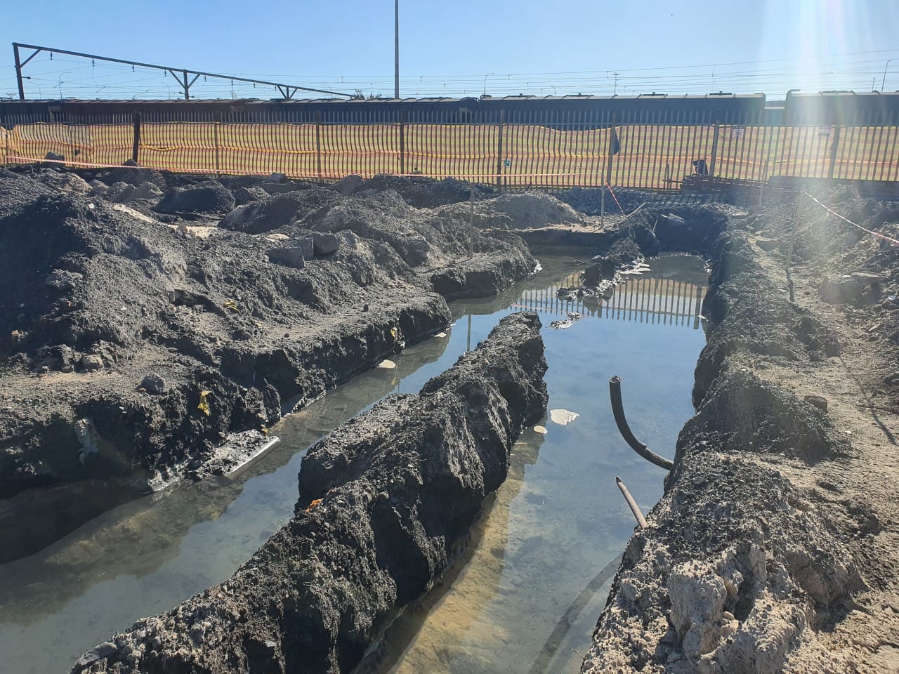 Excavated foundation trench with water adjacent to live rail corridor at Paarden Eiland