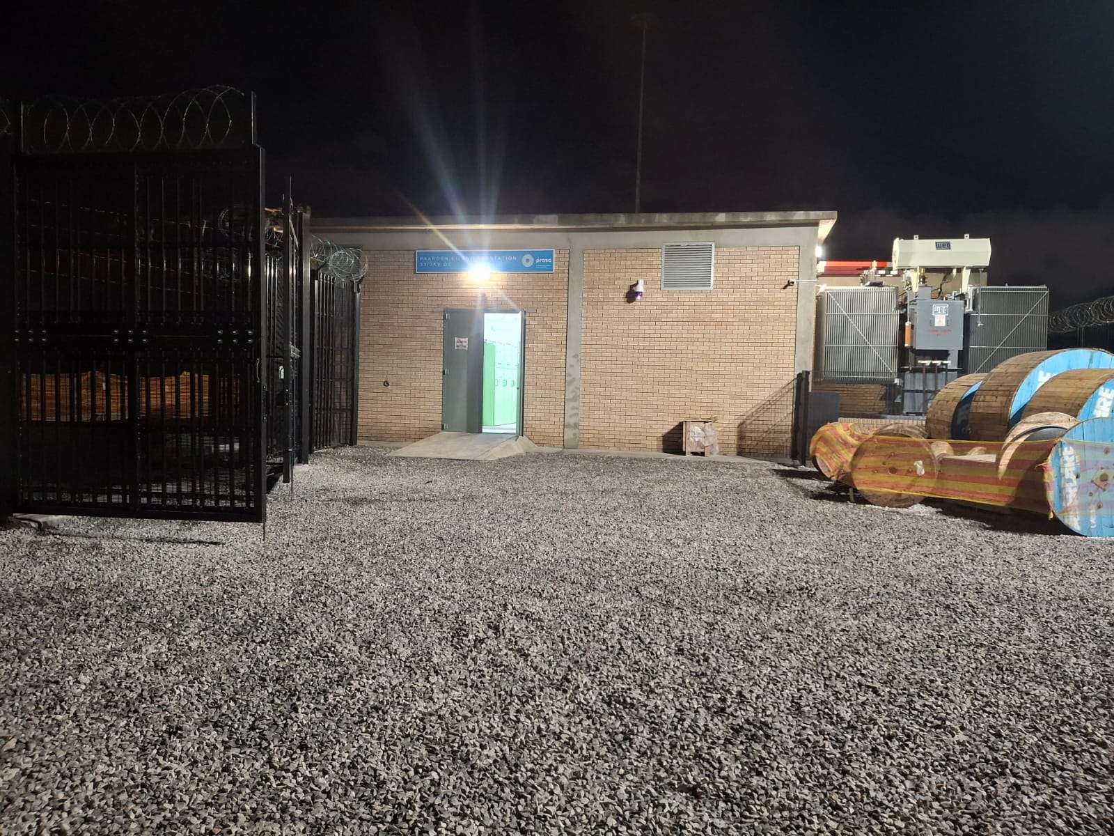 Paarden Eiland 33/3kV DC substation entrance at night with PRASA signage, transformer yard and cable drums